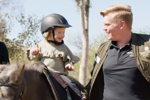 Sloane Spicer, a child with Down syndrome, on a horse at the Shea Center.
